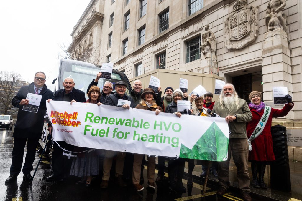 Íbúar frá Kehelland í Cornwall afhenda umsögn sína til breska orkumálaráðuneytisins í Whitehall, á bak við borða með áletruninni Renewable HVO Fuel for heating